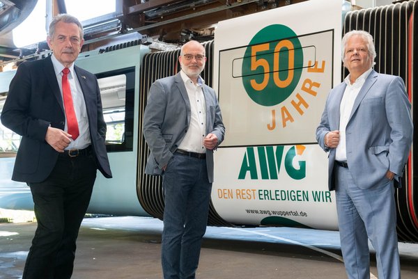 Klaus Jürgen Reese (links) , langjähriger Aufsichtsratsvorsitzender der AWG, Conrad Tschersich (Mitte), Technischer Geschäftsführer der AWG, und Martin Bickenbach (rechts) AWG-Geschäftsführer vor der "AWG-Schebebahn".  