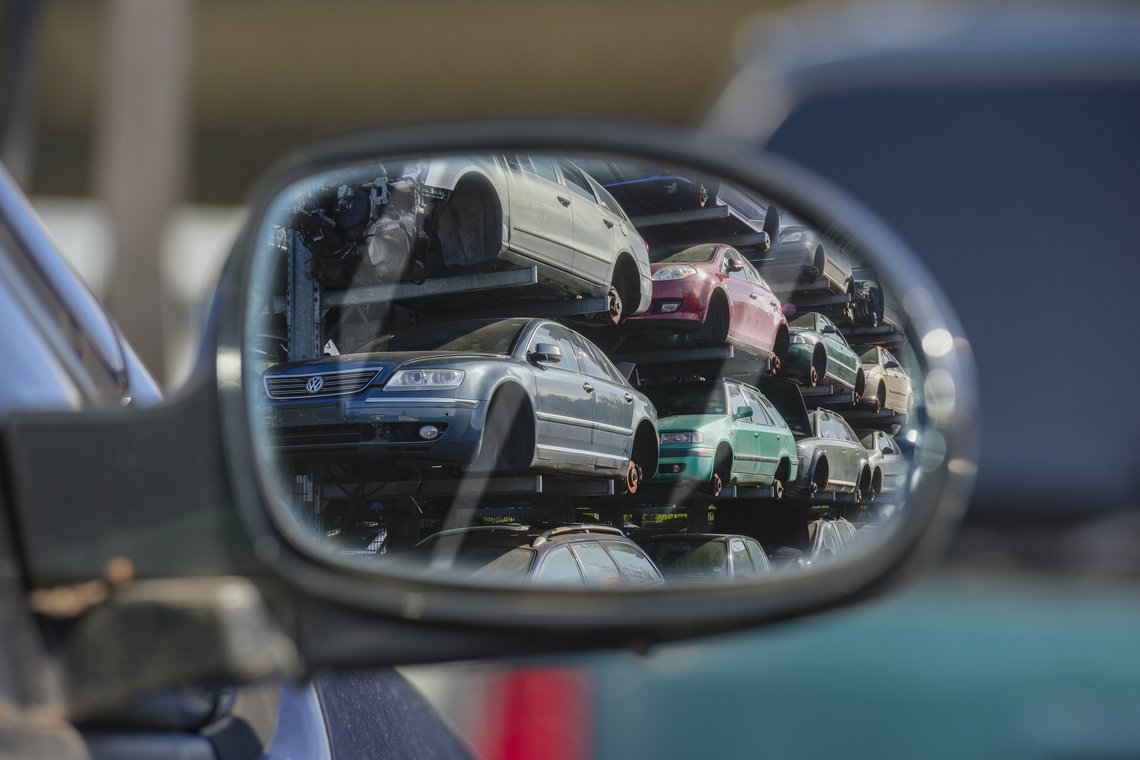 Spiegelung von Schrottautos in einem Autoseitenspiegel. 